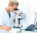 Young female researcher looking into a microscope